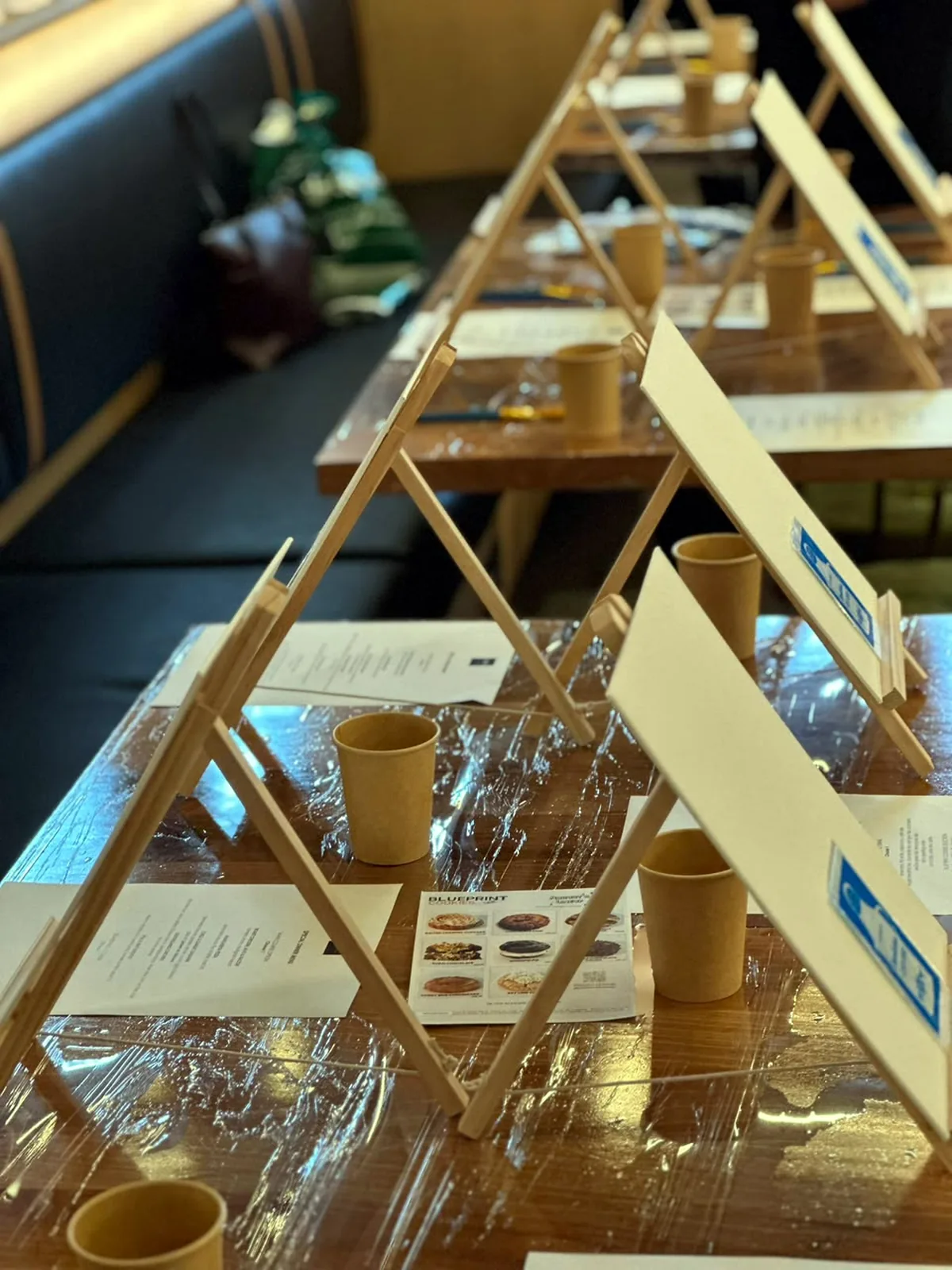Easels and canvases set up on café tables before the session begins