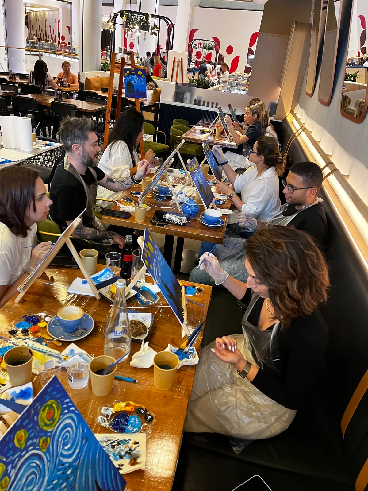 Guests painting Starry Night on tabletop easels at a CANVAS session