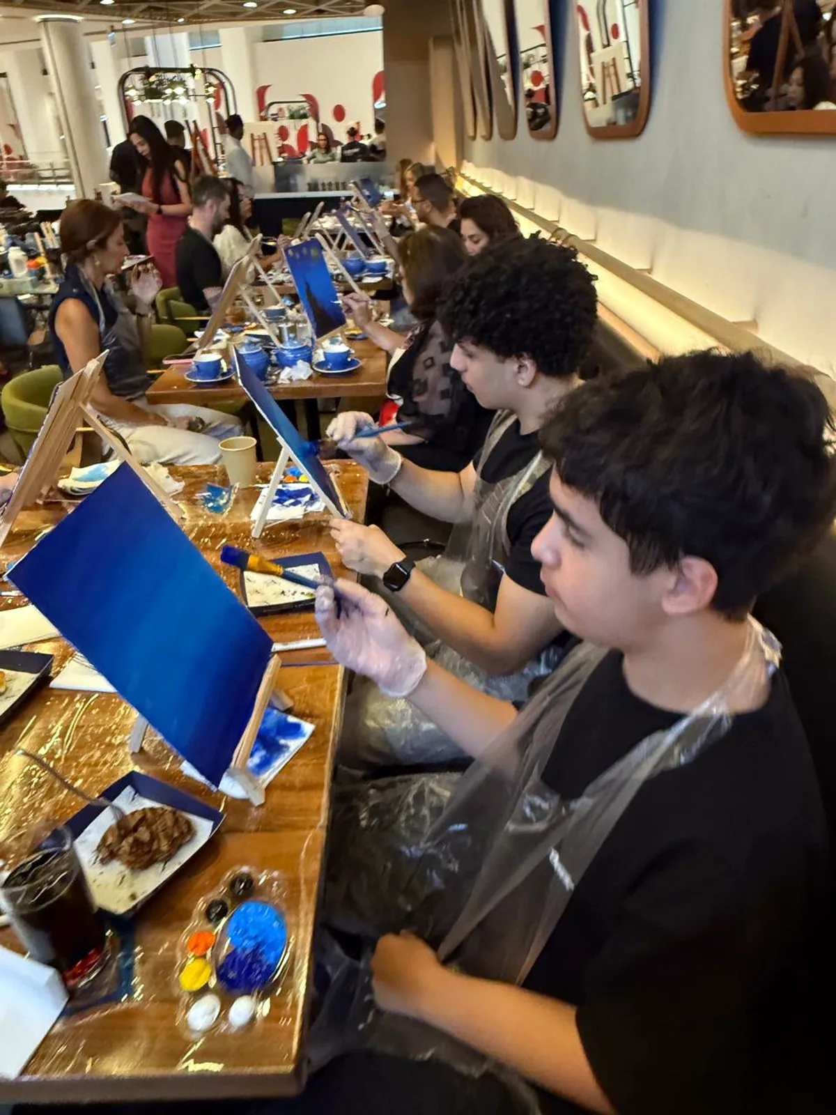 Guests painting Starry Night on tabletop easels at a CANVAS session