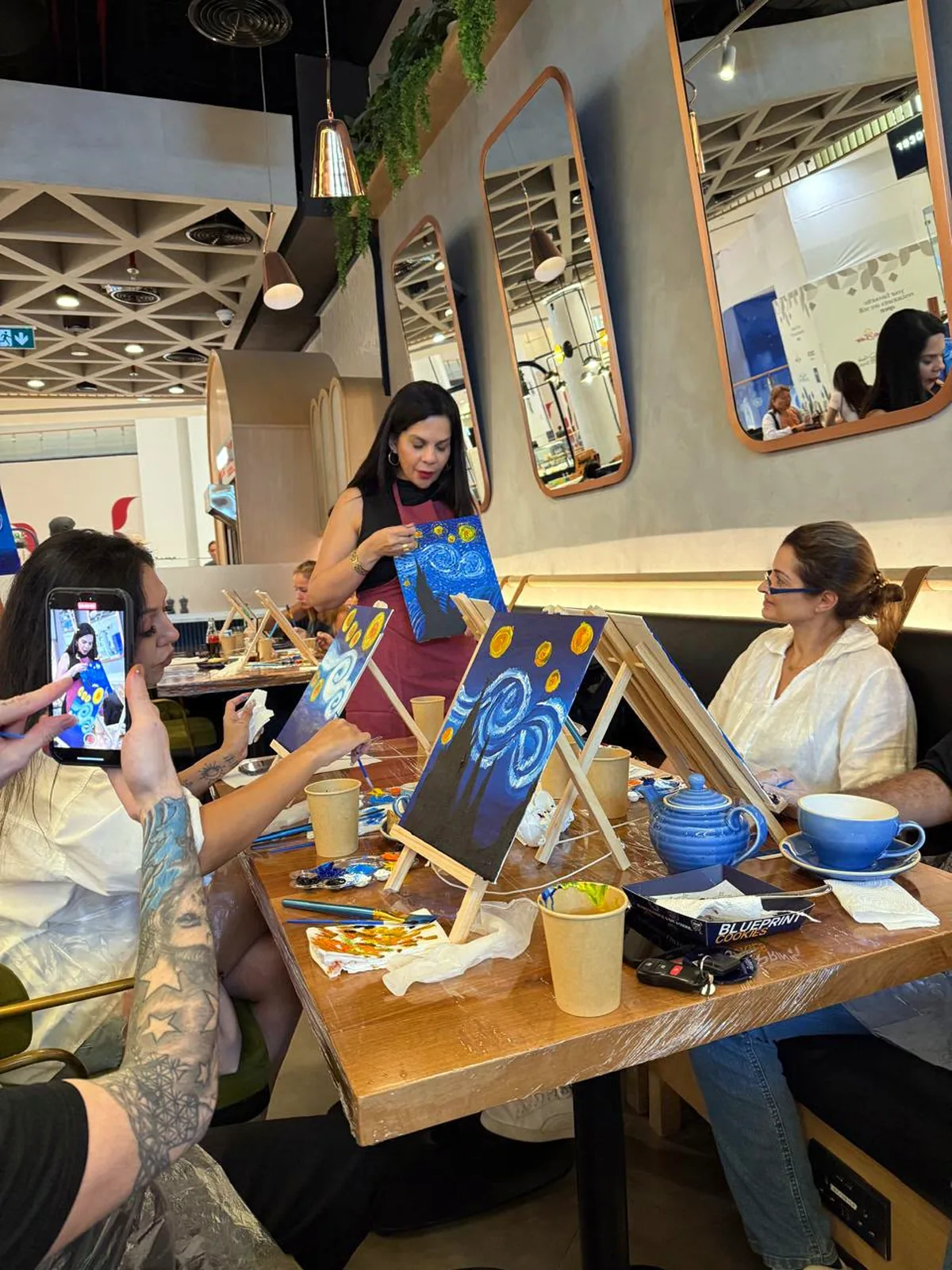 Guests enjoying a CANVAS Starry Night painting session in a Dubai café